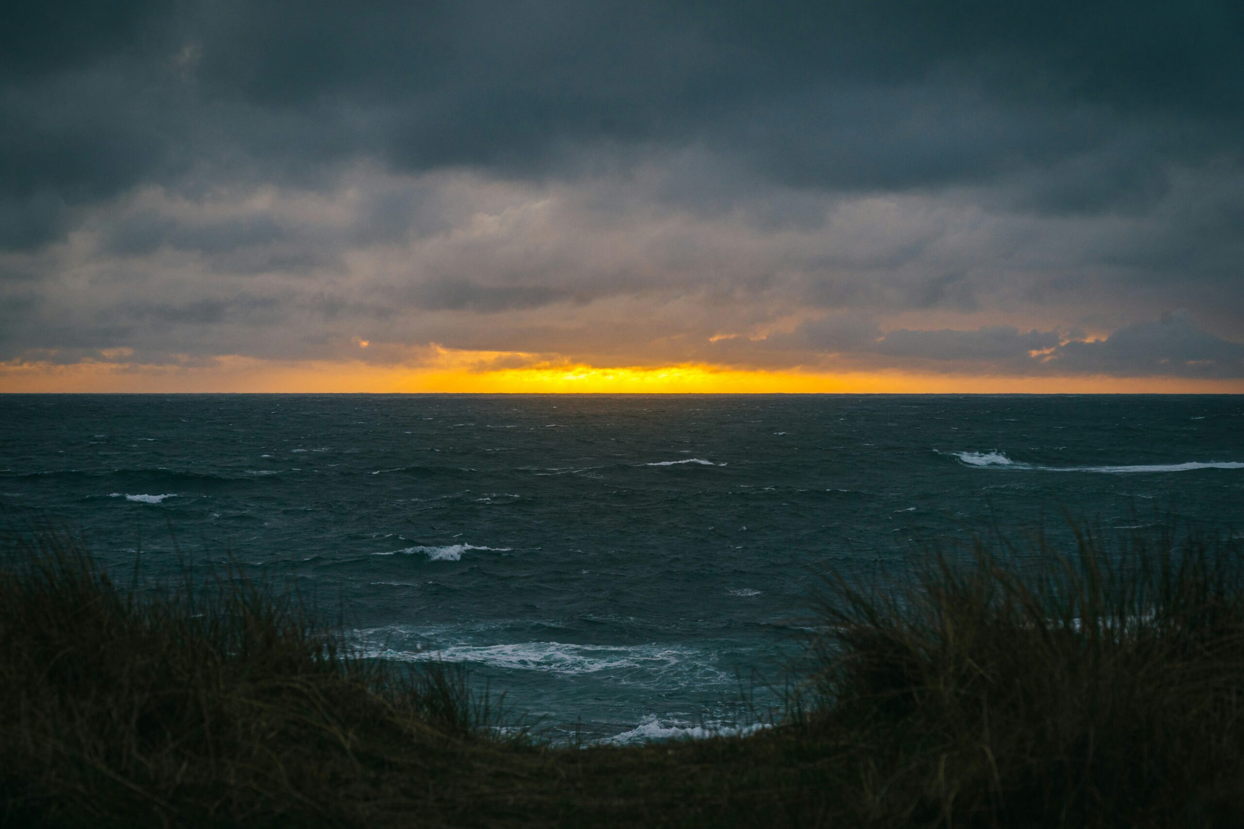 ocean view from the beach, sunset in the distance